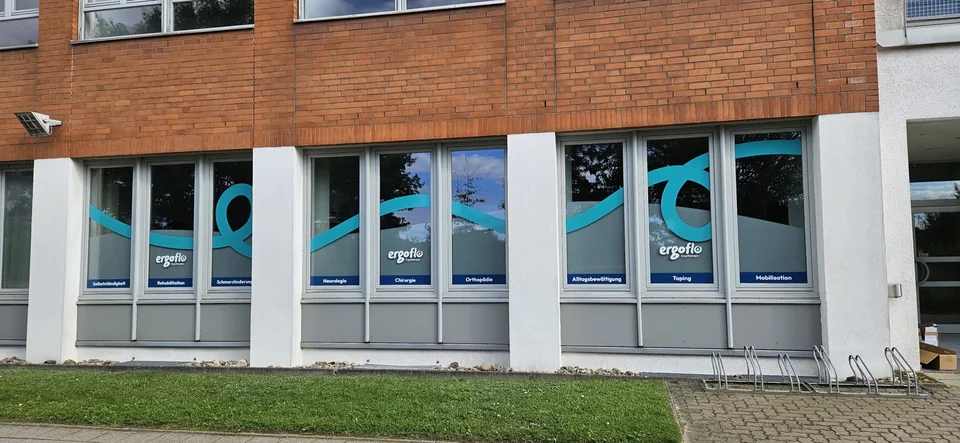 Fensterfront mit türkisfarbener Liniengrafik und ergoflo-Beschriftung