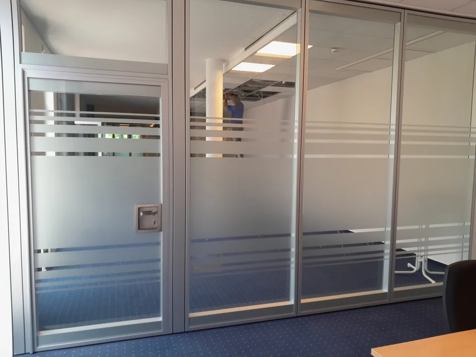 Glastrennwand und Tür mit matten Sichtschutzstreifen im Büro
