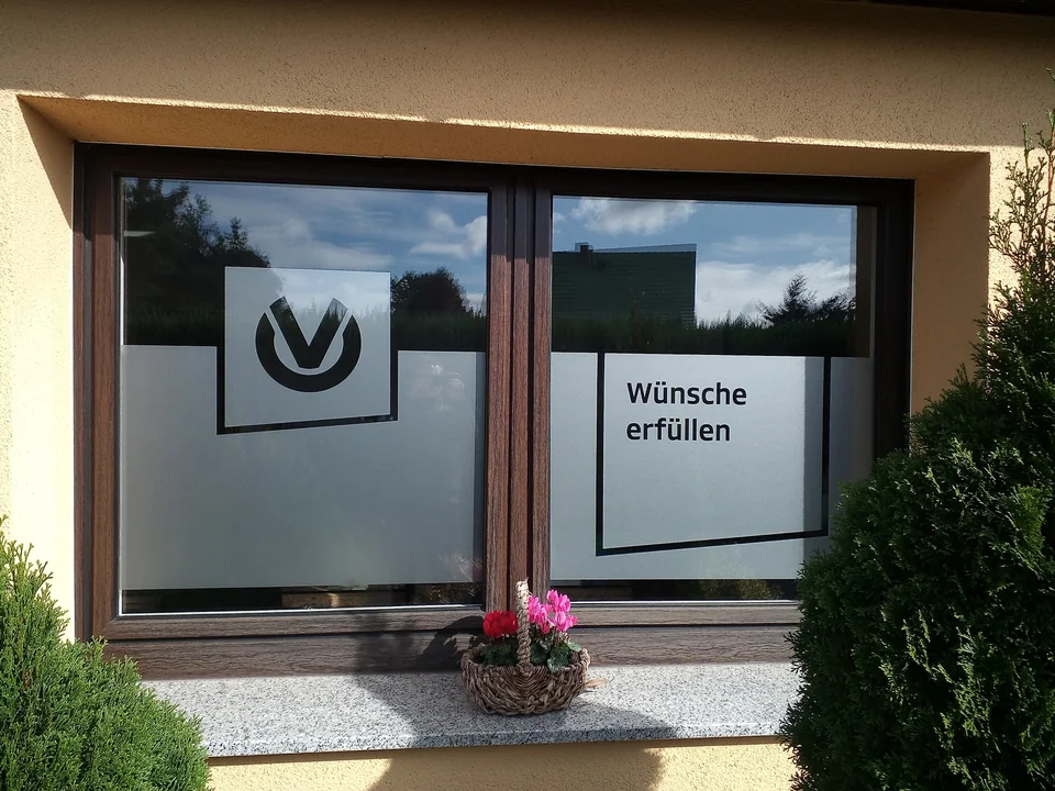 Fenster mit Milchglasfolie, ausgespartem Logo und Schriftzug