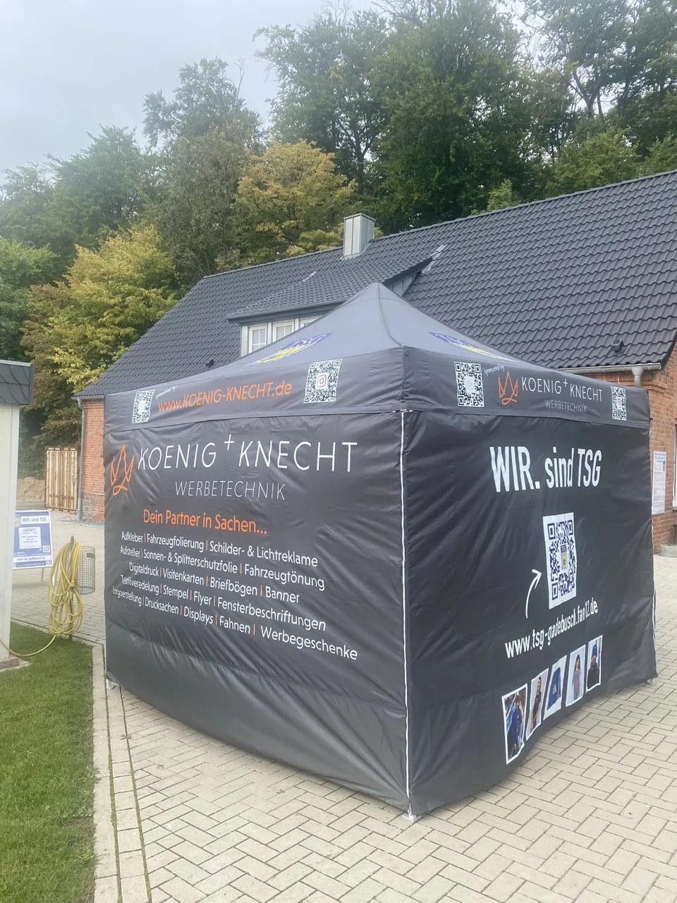 Grauer Eventpavillon mit KOENIG+KNECHT- und TSG-Beschriftung im Außenbereich